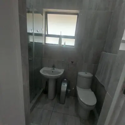 a bathroom with a toilet and a sink and a window at Mia's Accomidation in Kempton Park