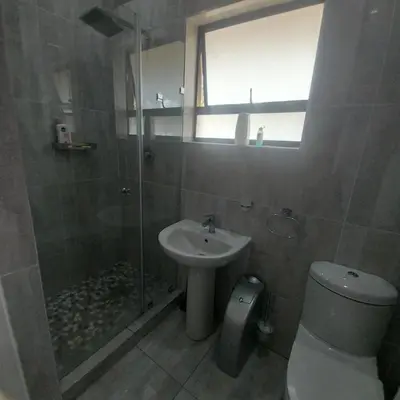 a bathroom with a shower and a toilet and a sink at Mia's Accomidation in Kempton Park