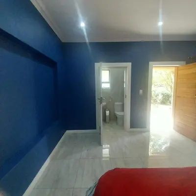 a blue room with a toilet and a door at Mia's Accomidation in Kempton Park