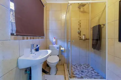 a bathroom with a toilet and a sink and a shower at Meadow Lane in Johannesburg