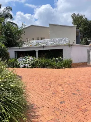 a house with a brick driveway in front of a building at The Ridge in Pretoria