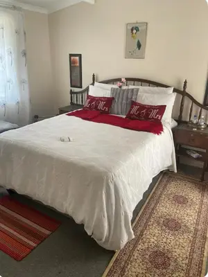 a bedroom with a large white bed with red pillows at The Ridge in Pretoria