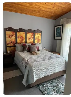 a bedroom with a large bed with a wooden ceiling at The Ridge in Pretoria