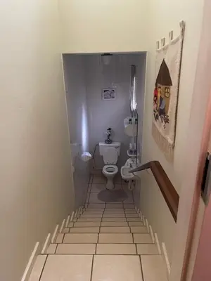 a small bathroom with a toilet and a staircase at The Ridge in Pretoria