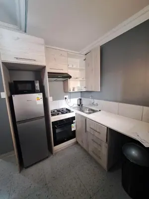 a small kitchen with a refrigerator and a stove at Selina Guesthouse in Kempton Park