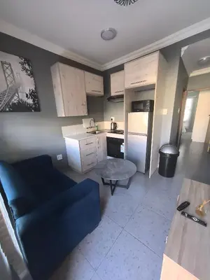 a kitchen with a blue couch in a room at Selina Guesthouse in Kempton Park
