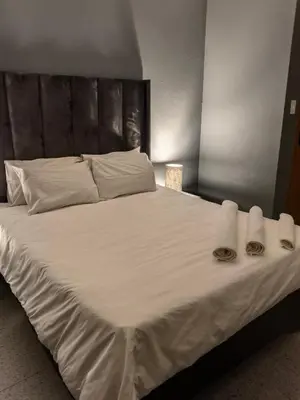 a large white bed with towels and pillows on it at Selina Guesthouse in Kempton Park