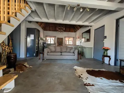 a living room with a couch and a staircase at Noah's Ark in Marloth Park