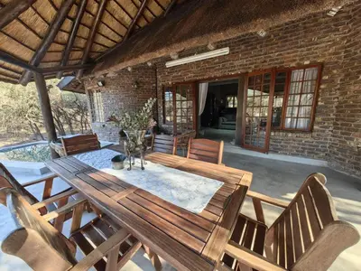 a wooden table and chairs on a patio at Noah's Ark in Marloth Park