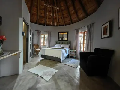 a bedroom with a bed and a couch in it at Noah's Ark in Marloth Park