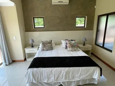 a bedroom with a large white bed with two windows at Euphoria Golf Estate House 196 Rooibok in Naboomspruit