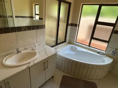 a bathroom with a sink and a tub next to a window at Euphoria Golf Estate House 196 Rooibok in Naboomspruit