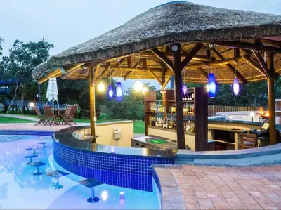 a swimming pool with a large umbrella and a bar at Euphoria Golf Estate House 196 Rooibok in Naboomspruit