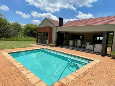 a swimming pool in front of a house at Euphoria Golf Estate House 196 Rooibok in Naboomspruit