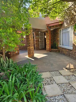 a brick house with a driveway leading to the front door at Krantz-Aloe guesthouse in Winterkamp