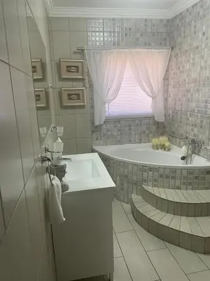 a white bathroom with a tub and a sink at Krantz-Aloe guesthouse in Winterkamp