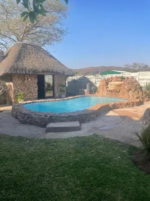 a swimming pool in a yard with a building at Krantz-Aloe guesthouse in Winterkamp