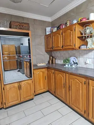 a kitchen with wooden cabinets and a refrigerator at Krantz-Aloe guesthouse in Winterkamp