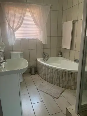 a bathroom with a tub and a toilet and a sink at Krantz-Aloe guesthouse in Winterkamp