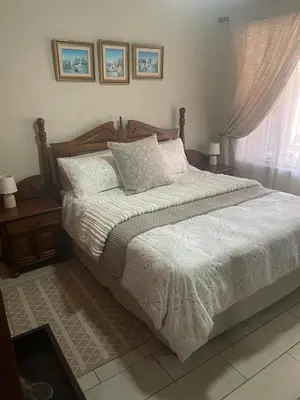 a bedroom with a bed with white sheets and a window at Krantz-Aloe guesthouse in Winterkamp