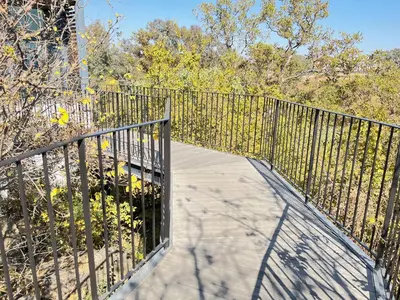 a walkway with a metal fence and trees at Secure 1 Bedroom Apartment in Midrand, Waterfall City - Lock Up and Go - Free WIFI and Parking - 4A Elizabeth Place in Midrand