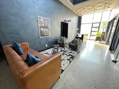 a living room with a couch and two chairs at Spacious 2 Bedroom Apartment in Midrand, Waterfall City - Business and Family friendly - 13A Elizabeth Place in Midrand