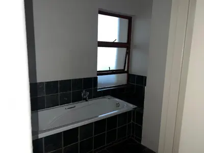 a bath tub in a bathroom with a window at Angelic hut in Midrand