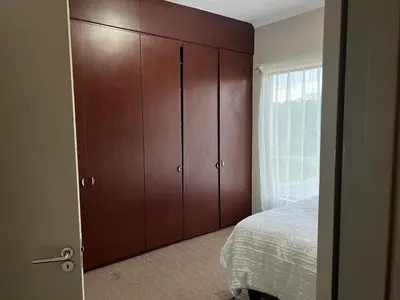 a bedroom with brown cabinets and a bed in it at Angelic hut in Midrand