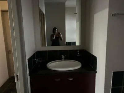 a person taking a picture of a sink in a bathroom at Angelic hut in Midrand