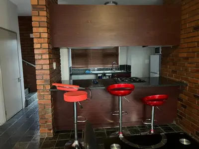 a kitchen with red stools in the middle of it at Angelic hut in Midrand