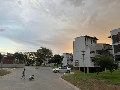 two children playing in a parking lot with a car at Angelic hut in Midrand