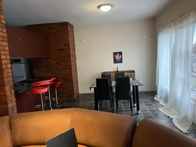 a living room with a couch and a table and chairs at Angelic hut in Midrand