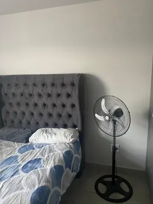 a bedroom with a bed and a fan next to it at One Bedroom Apartment at Circa in Pretoria