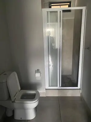 a bathroom with a toilet and a glass shower at One Bedroom Apartment at Circa in Pretoria