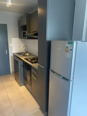 a kitchen with a refrigerator and a stove at One Bedroom Apartment at Circa in Pretoria
