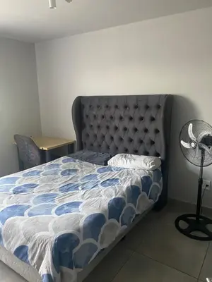 a bedroom with a bed with a blue and white comforter at One Bedroom Apartment at Circa in Pretoria