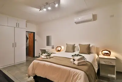 a bedroom with a large bed with two pillows on it at Finch Nest in Marloth Park