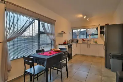 a kitchen with a table and chairs in a kitchen at Finch Nest in Marloth Park
