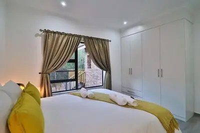 a bedroom with a large white bed with towels on it at Krokodil Rus in Marloth Park
