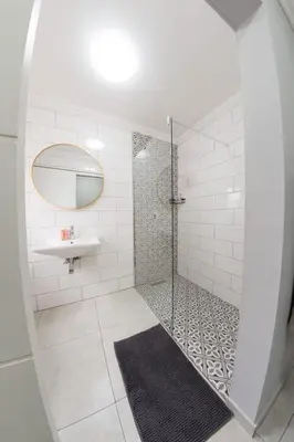 a bathroom with a shower with a sink and a mirror at La Grace in Kempton Park