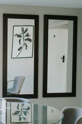 two framed pictures on a wall with a table and chairs at La Grace in Kempton Park