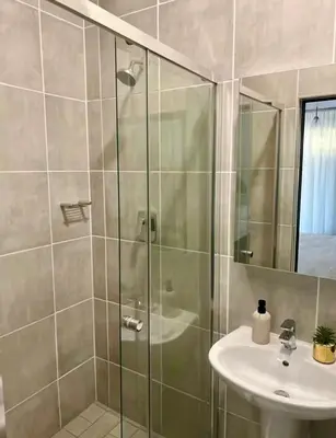 a bathroom with a shower and a sink at Modern Retreat in Pretoria with Lagoon Pool & Gym in Pretoria