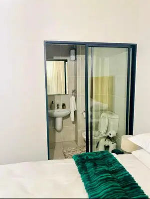 a bedroom with a bathroom with a toilet and a sink at Modern Retreat in Pretoria with Lagoon Pool & Gym in Pretoria