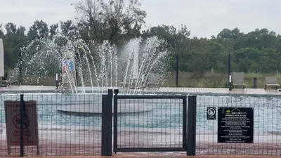 a fountain in a park with a sign in front of it at Modern Retreat in Pretoria with Lagoon Pool & Gym in Pretoria