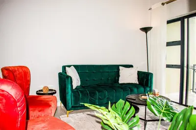 a living room with a green couch and a table at Modern Retreat in Pretoria with Lagoon Pool & Gym in Pretoria