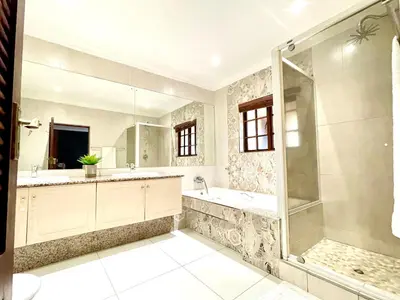 a bathroom with a shower and a tub and a sink at BB Hers Cheesy in Midrand