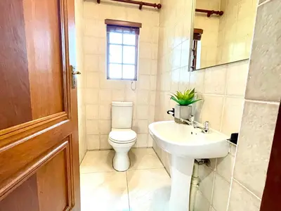 a bathroom with a toilet and a sink at BB Hers Cheesy in Midrand