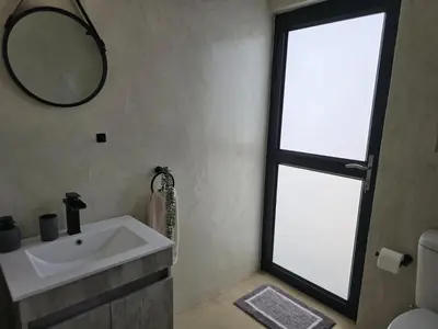 a bathroom with a sink and a mirror at Taíta Lodge in Marloth Park