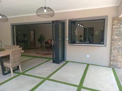 a living room with a table and a mirror at Taíta Lodge in Marloth Park