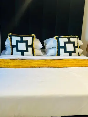 two beds with blue and white pillows on them at Modern Retreat in Waterfall Midrand with Pool & Restaurant in Kyalami